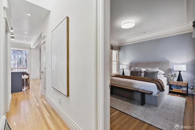 hallway featuring crown molding and light hardwood / wood-style floors