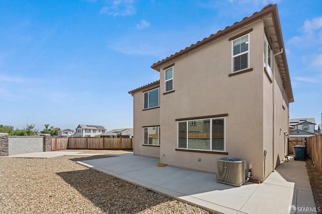 rear view of property featuring central AC and a patio area