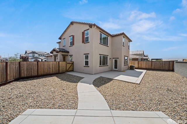 rear view of property featuring central AC unit and a patio