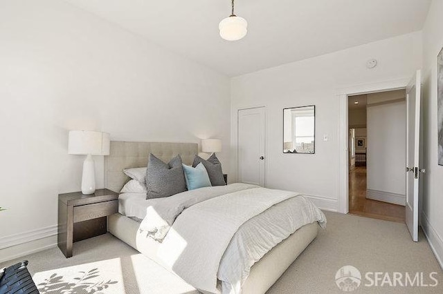 bedroom with light carpet and baseboards