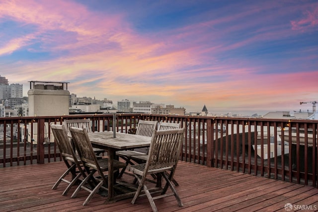 wooden deck with a view of city and outdoor dining area