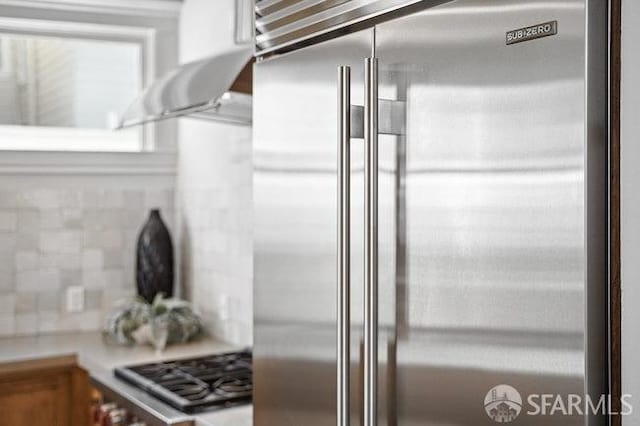room details with backsplash, light countertops, and appliances with stainless steel finishes