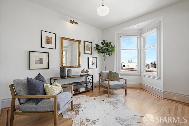 sitting room with baseboards and wood finished floors