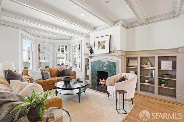 living room with crown molding, beamed ceiling, a fireplace, recessed lighting, and wood finished floors