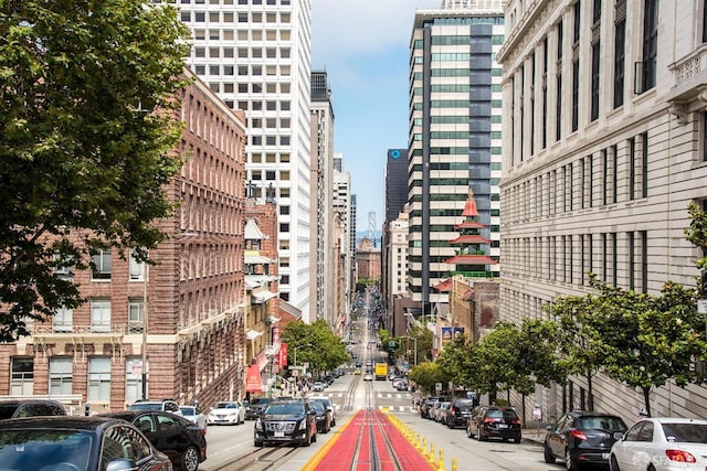 view of street with street lighting, sidewalks, and a city view