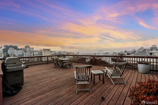 deck at dusk featuring a grill and a city view