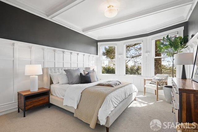 bedroom featuring a decorative wall, light colored carpet, beamed ceiling, and ornamental molding