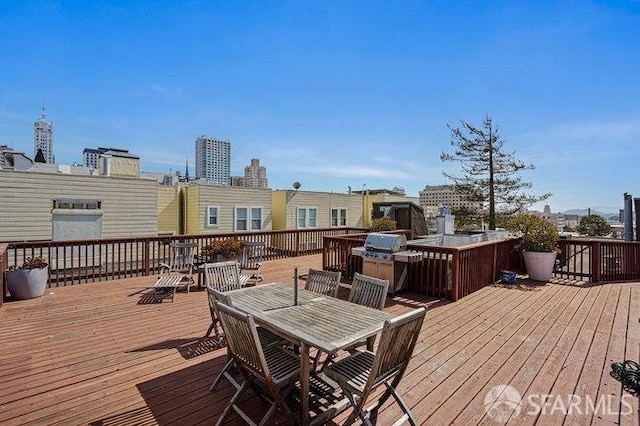 wooden deck with outdoor dining space and a grill