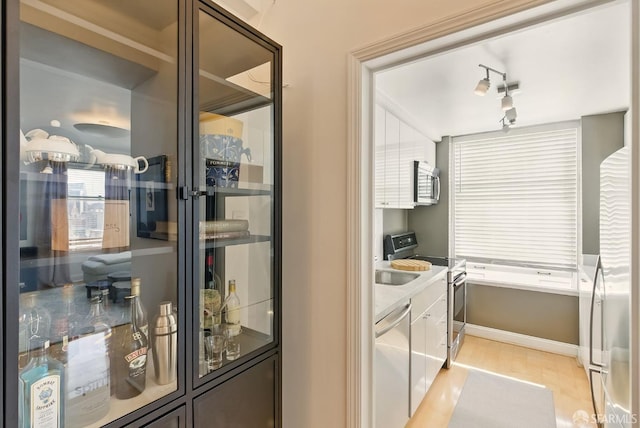 631 Ofarrell St Unit 702, San Francisco, CA 94109 - kitchen featuring appliances with stainless steel finishes, baseboards, white cabinetry, and light wood-type flooring