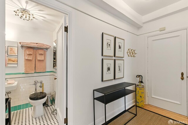631 Ofarrell St Unit 702, San Francisco, CA 94109 - hall featuring tile patterned floors, a wainscoted wall, tile walls, and a sink