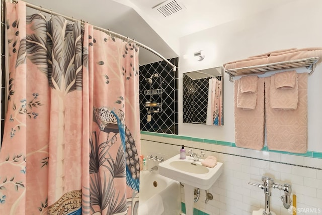 631 Ofarrell St Unit 702, San Francisco, CA 94109 - bathroom featuring shower / tub combo with curtain, tile walls, and a sink