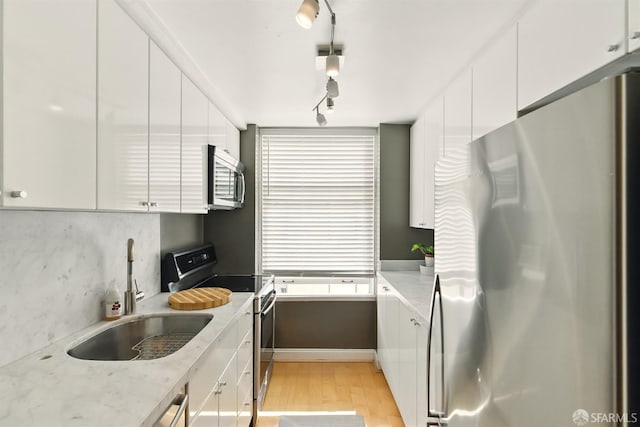 631 Ofarrell St Unit 702, San Francisco, CA 94109 - kitchen featuring stainless steel appliances, a sink, light wood-style floors, modern cabinets, and white cabinets