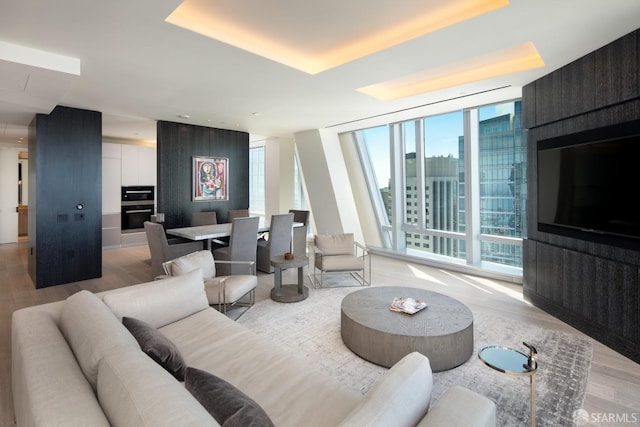 living room featuring a wall of windows and light hardwood / wood-style flooring