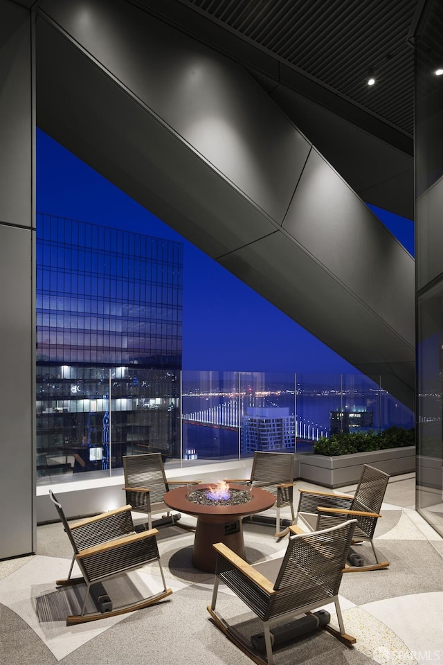181 Fremont St Unit 58A, San Francisco, CA 94105 - patio at night featuring an outdoor fire pit, a view of city lights, a water view, and a patio