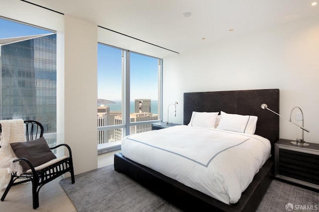 bedroom with a water view and hardwood / wood-style floors