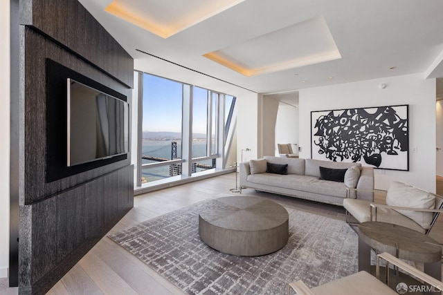 181 Fremont St Unit 58A, San Francisco, CA 94105 - living room featuring a raised ceiling, wood finished floors, floor to ceiling windows, and a water view