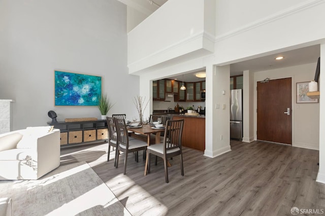 dining space featuring a towering ceiling and dark hardwood / wood-style floors