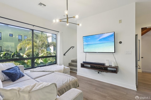 bedroom featuring visible vents, a notable chandelier, baseboards, and wood finished floors