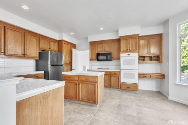 4737 Crestone Peak Dr, Antioch, CA 94531 - kitchen featuring decorative backsplash, brown cabinetry, tile countertops, and white appliances