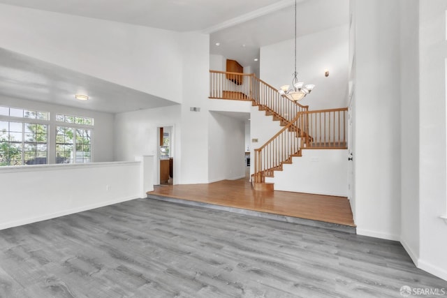 4737 Crestone Peak Dr, Antioch, CA 94531 - unfurnished living room with an inviting chandelier, stairs, wood finished floors, baseboards, and high vaulted ceiling
