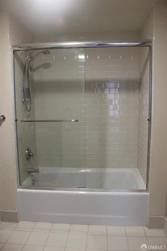 bathroom featuring tile patterned flooring and bath / shower combo with glass door