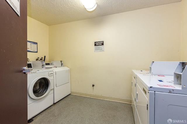 washroom with a textured ceiling and washer and clothes dryer