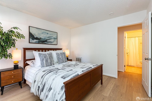 bedroom with light hardwood / wood-style floors and a textured ceiling