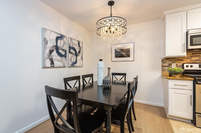 dining space with an inviting chandelier and light hardwood / wood-style floors