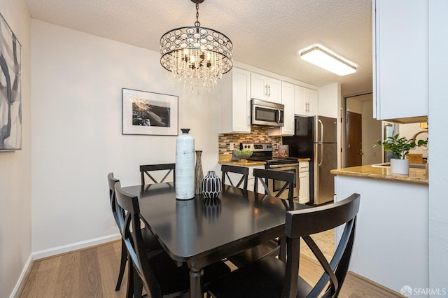 dining space featuring dark hardwood / wood-style flooring, a chandelier, and a textured ceiling