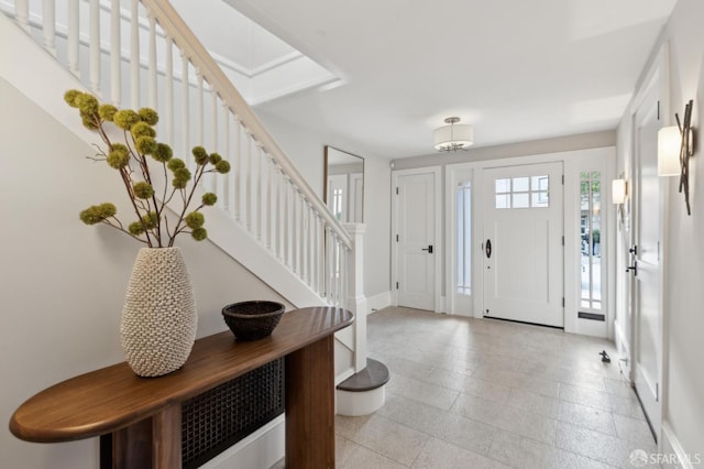 entrance foyer featuring baseboards and stairs