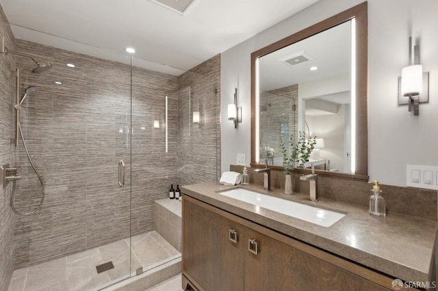 full bathroom featuring visible vents, a stall shower, and vanity