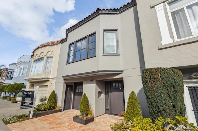 view of front of house with a tiled roof and stucco siding