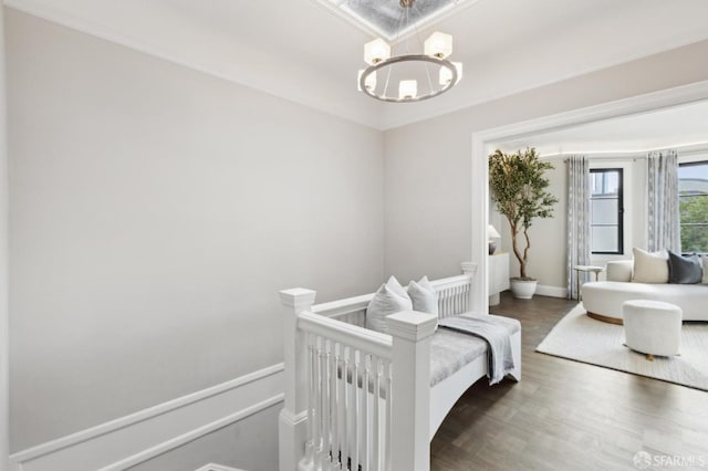 bedroom with dark wood-type flooring, baseboards, and a chandelier