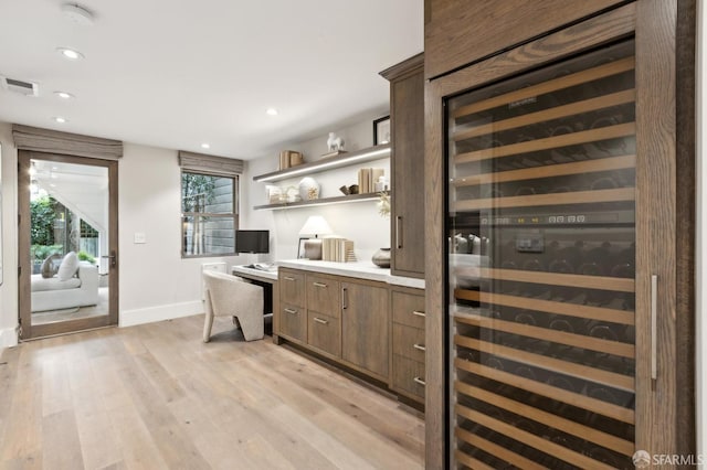 bar featuring visible vents, beverage cooler, built in desk, recessed lighting, and light wood-style floors