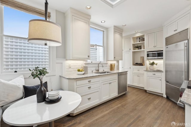 kitchen featuring wood finished floors, open shelves, a sink, white cabinets, and appliances with stainless steel finishes