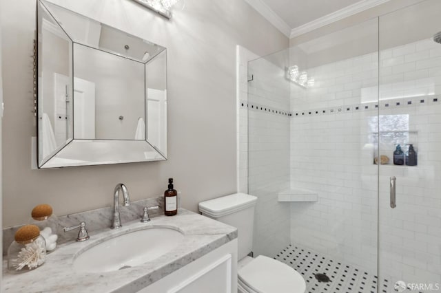 bathroom with a shower stall, toilet, vanity, and ornamental molding