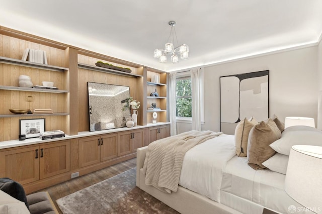 bedroom featuring an inviting chandelier and wood finished floors