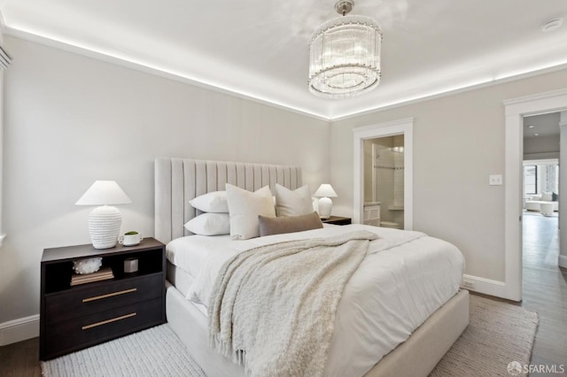 bedroom featuring a chandelier, baseboards, wood finished floors, and radiator heating unit