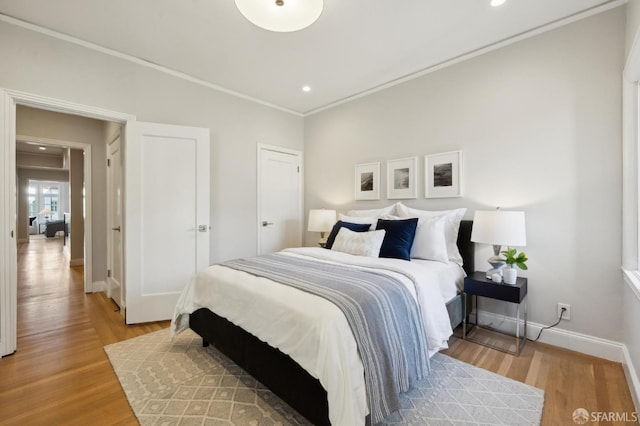 bedroom with light hardwood / wood-style floors and ornamental molding