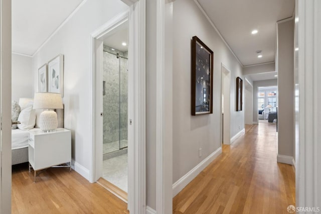 corridor featuring light hardwood / wood-style floors and crown molding