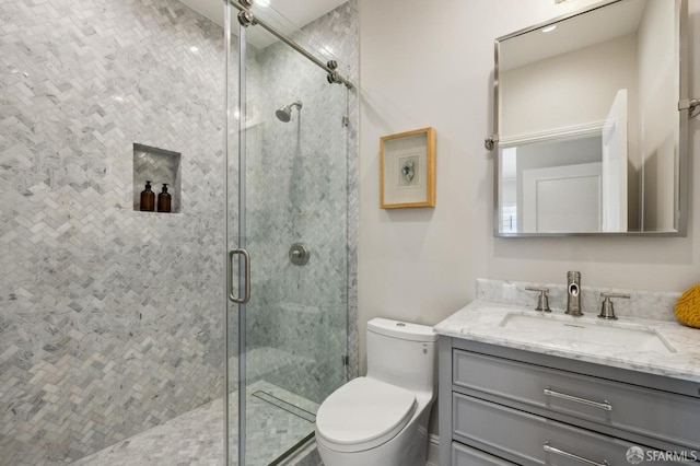 bathroom with vanity, an enclosed shower, and toilet