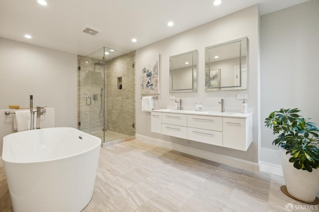 bathroom with vanity and shower with separate bathtub