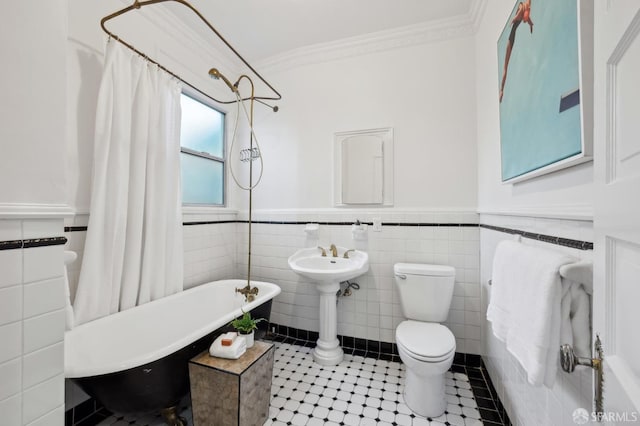 bathroom with crown molding, toilet, and tile walls