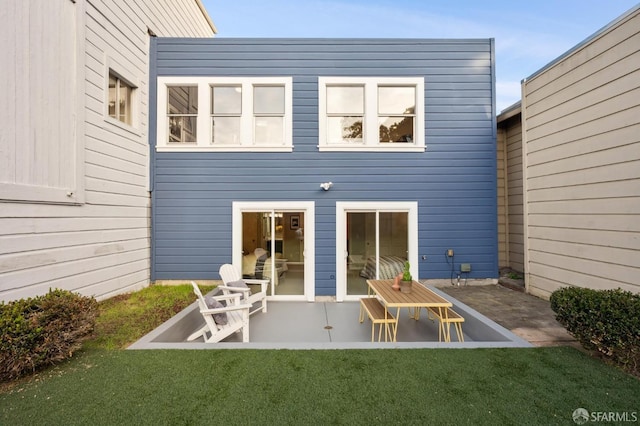 rear view of house featuring a yard and a patio area