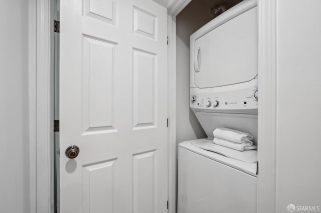 clothes washing area featuring stacked washer / drying machine