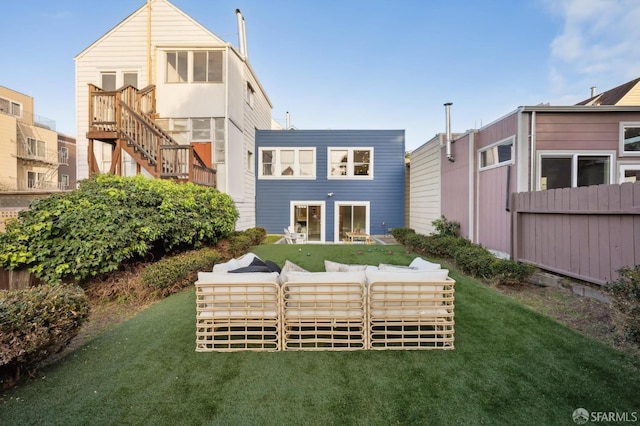 rear view of property with a lawn and outdoor lounge area