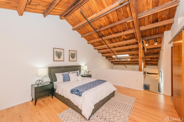 bedroom with lofted ceiling with beams, rail lighting, wooden ceiling, and light hardwood / wood-style flooring