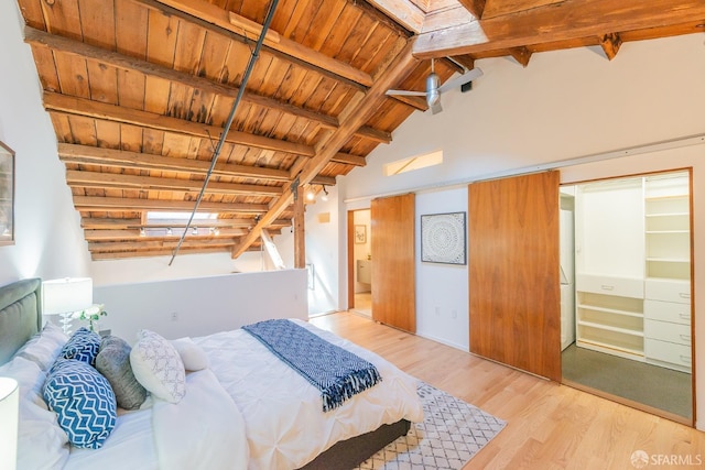 bedroom with vaulted ceiling with beams, wooden ceiling, and light hardwood / wood-style floors