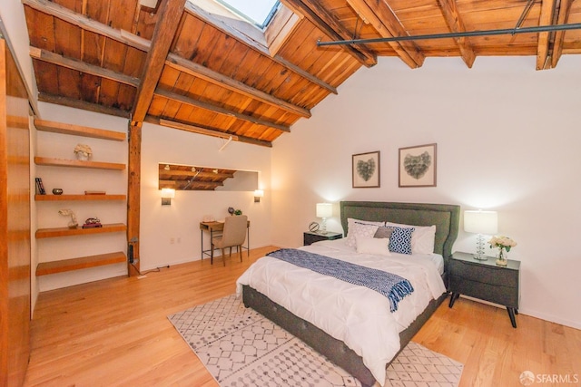 bedroom featuring light hardwood / wood-style floors, wood ceiling, and a skylight