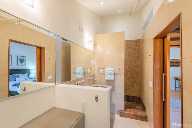 bathroom featuring tile walls and sink